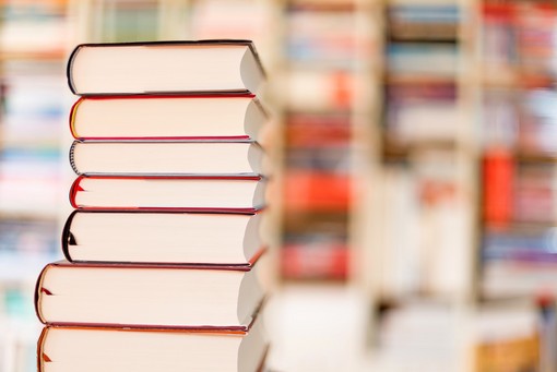 Symbolbild Serviceleistung Bewerbungs-Coaching Stapel von Sachbüchern mit verschwommenem Hintergrund